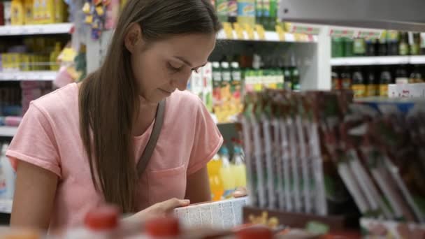 Retrato de la mujer eligiendo mercancías en el departamento de comestibles del centro comercial — Vídeos de Stock