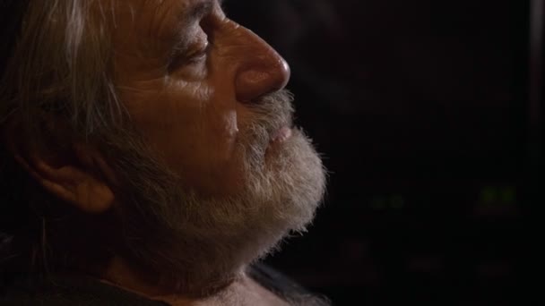 Profil portrait de fatigué senior homme frotte ses yeux à chambre noire — Video