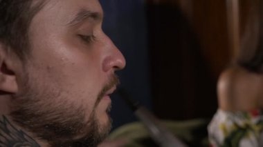 Kız adamla kafede kanepede oturan ve bir nargile Sigara