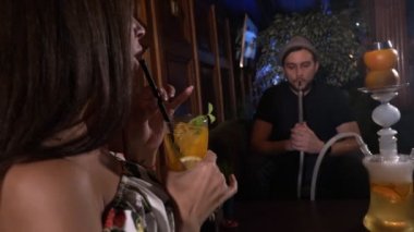 Kız adamla kafede kanepede oturan ve bir nargile Sigara