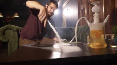 Sigara nargile genç adam ve yapar kasırga masanın üzerinde duman tarafından hüner.