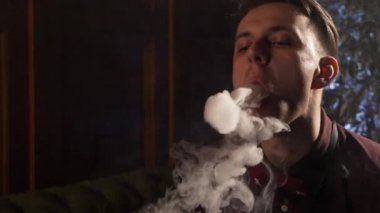 Nargile ve yapar halkalar duman sigara yakışıklı genç adam.