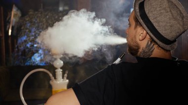 Adam kafede kanepede oturan ve bir nargile Sigara