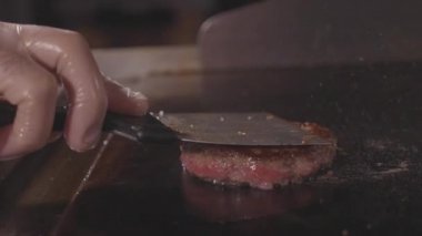Pişirme ve spatula sulu et tarafından hamburger için tuşuna basarak Şef sokak gıda