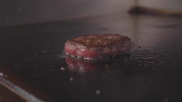 Restaurante de comida callejera, primer plano asar hamburguesas chuleta en la superficie de freír . — Vídeos de Stock