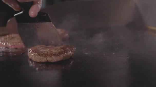 Street food restaurant, close-up grilling tree burgers cutlet on frying surface — Stock Video