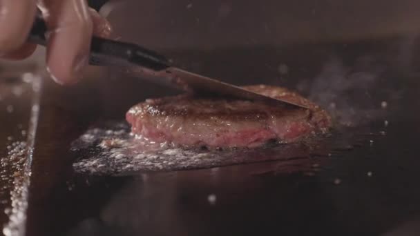 Kocken matlagning och trycka av spatel saftigt kött för hamburgare, snabbmat — Stockvideo