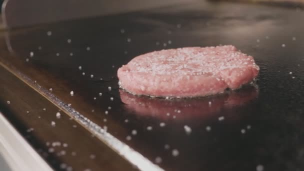 Primer plano de chuleta de carne cruda para freír hamburguesas en la parrilla comercial eléctrica . — Vídeo de stock