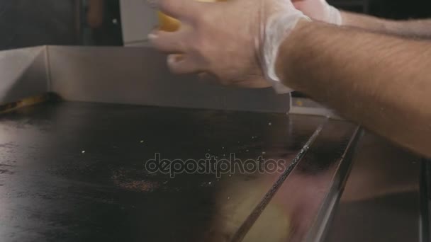 Chef poniendo un bollo para hamburguesa en la parrilla comercial eléctrica . — Vídeo de stock