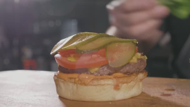 准备一个汉堡牛肉里索莱与奶酪的厨师手的特写镜头 — 图库视频影像