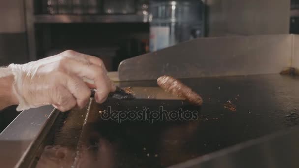 Chef volteando chuleta para hamburguesa en la parrilla comercial eléctrica, cámara lenta — Vídeo de stock