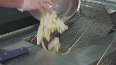 Bir patates kızartması yemek pişirmek için bir fritöz için dökme şefler eller