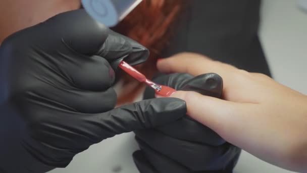 Samice červená dělá lázeňské procedury pro nehty klienta — Stock video