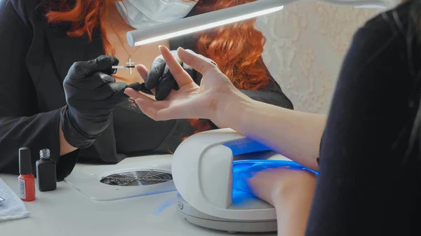 Vrouwelijke rood maakt een spa-procedure voor de nagels van de client — Stockfoto