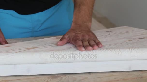 Man polishing wooden step and checking surface for smoothness — Stock Video