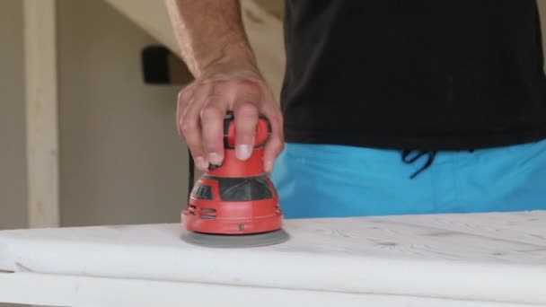 Timmerman schuren van een houten stap met een elektrische schuurmachine in workshop closeup — Stockvideo