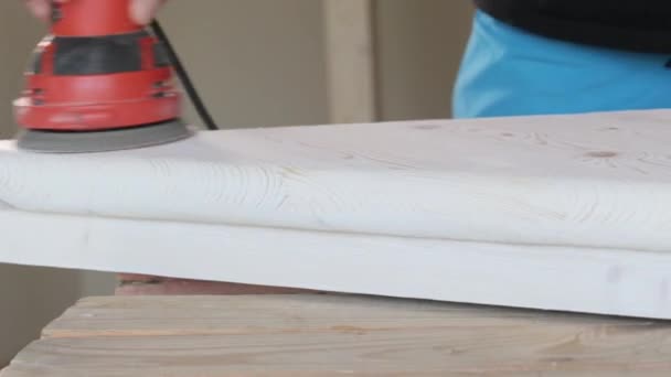 Carpintero puliendo un escalón de madera con una lijadora eléctrica en primer plano del taller — Vídeo de stock