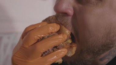 Hangry genç adam yeme hamburger, ağır çekim yakın çekim