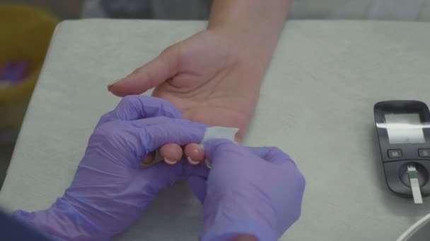 Artsen handen in handschoenen nemen vinger bloedonderzoek van vrouwelijke patiënt. — Stockvideo