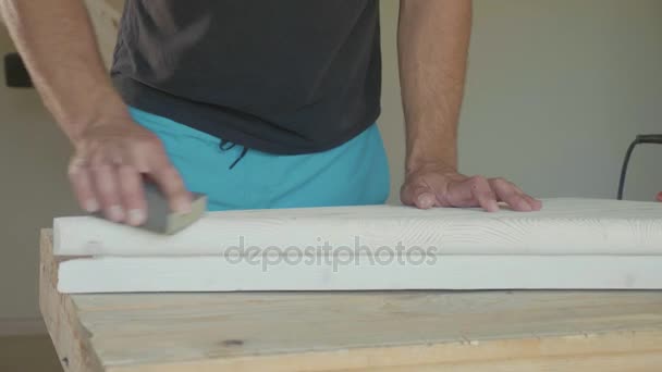 Nahaufnahme männlicher Hände, die Holzstufen mit Schleifpapier polieren — Stockvideo