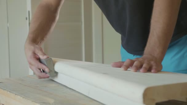 Крупный план мужских рук, полирующих деревянные ступеньки наждачной бумагой — стоковое видео