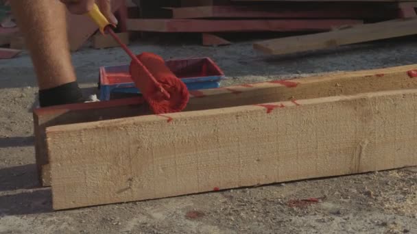 Tablero de madera largo del barniz del tinte del trabajador por el rodillo de producción . — Vídeo de stock