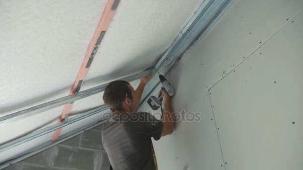Trabalhador montagem de construção de metal para drywall em uma casa recém-construída — Vídeo de Stock