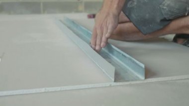 Yeni inşa edilen evde yüklemek için bir alçıpan levha işaretleme işçisi.