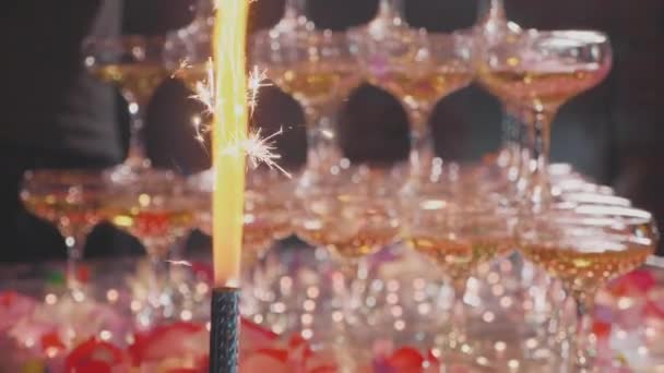 Serveur versant du champagne dans des verres à pyramide avec des confettis et des fontaines — Video