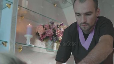 Lüks spa salonda iş yerinde genç erkek maasagist portresi.