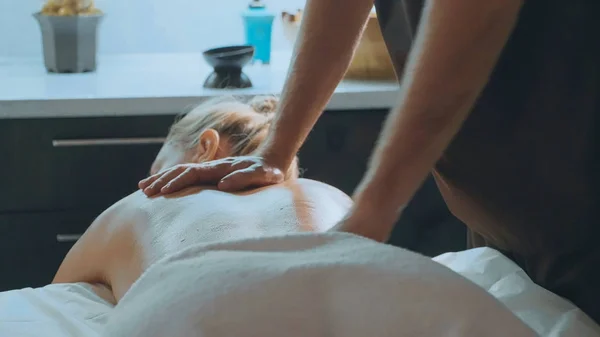 Mannelijke massagist masseren aantrekkelijke ladys terug. — Stockfoto