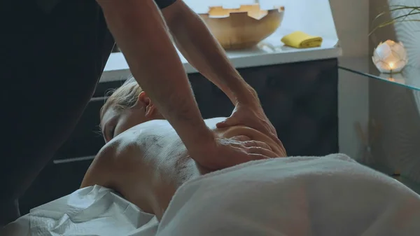 Male massagist massaging attractive ladys back. — Stock Photo, Image