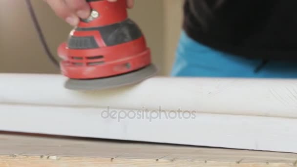 Плотник полирует деревянную ступеньку электрошлифовальным станком в мастерской крупным планом — стоковое видео