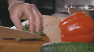 Şef biraz maydanoz kesme tahtası üzerinde doğrama eldiven kapatalım