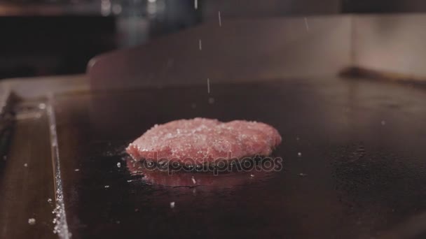 Chef cooking and salting fresh meat cutlet for the burger, street food — Stock Video