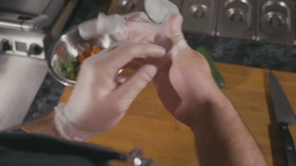 Chef kok gerechten in restaurant, hij zet de latex handschoenen voorbereiden — Stockvideo