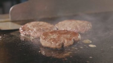 Pirzola burger elektrikli ızgara için bir iki parça peynir koyarak Şef