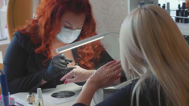 Vrouwelijke rood maakt een spa-procedure voor de nagels van de client — Stockvideo