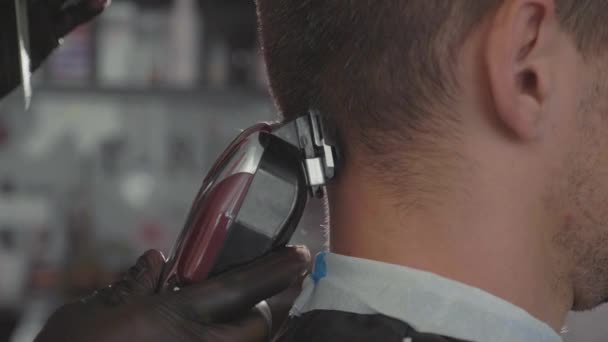 Close up de homens corte de cabelo com cortador de cabelo na barbearia . — Vídeo de Stock