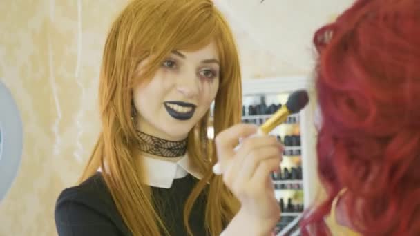 Artista con maquillaje de halloween aplicando maquillaje de halloween en la cara de modelos . — Vídeos de Stock