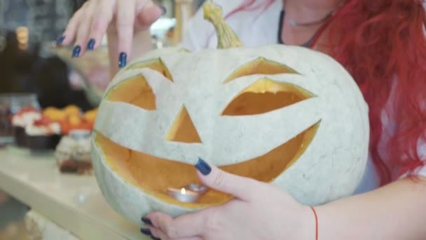 Close-up portrait of redhead woman with halloween makeup with pumpkin. — Stock Video