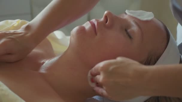 Cosmetologo sta pulendo le donne faccia da spugna di cotone al salone spa — Video Stock