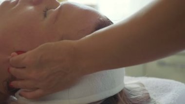 Güzel genç kadın lüks spa Salonu, yüz masajı ile rahatlatıcı yakın çekim.