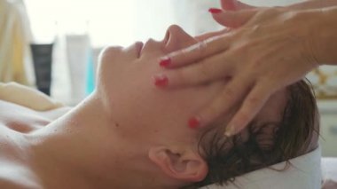 Güzel genç kadın lüks spa Salonu, yüz masajı ile rahatlatıcı yakın çekim.
