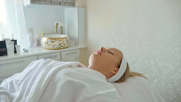 Schöne Frau im Bademantel liegend und wartend Gesichtsbehandlung im Wellness-Salon — Stockfoto