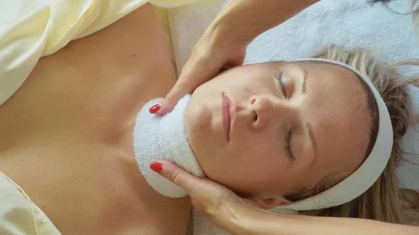 Beautiful young woman relaxing with face massage at luxury spa salon, close-up. — Stock Photo, Image