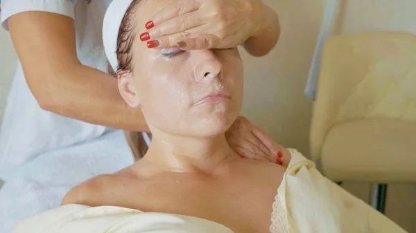 Atractiva mujer en el spa club de salud recibiendo un procedimiento facial y masaje —  Fotos de Stock