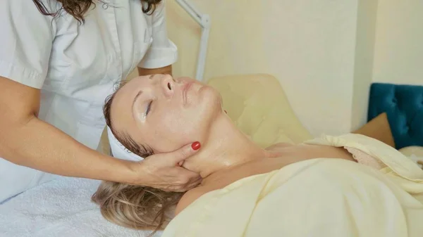 Привлекательная женщина в оздоровительном спа-клубе получает процедуру для лица и массаж — стоковое фото
