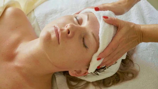 Beautiful young woman relaxing with face massage at luxury spa salon, close-up. — Stock Photo, Image