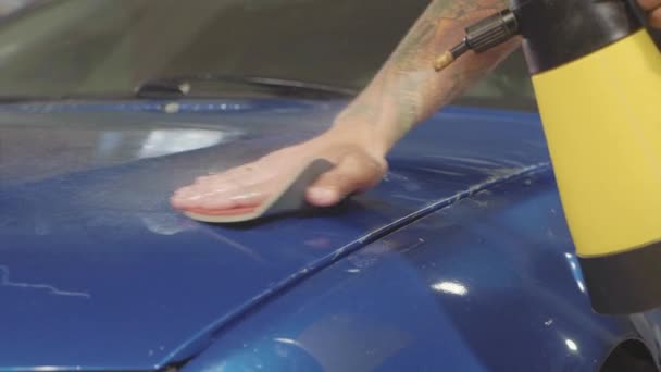 Close-up de mestre polimento carro azul profundo na oficina, câmera lenta — Vídeo de Stock